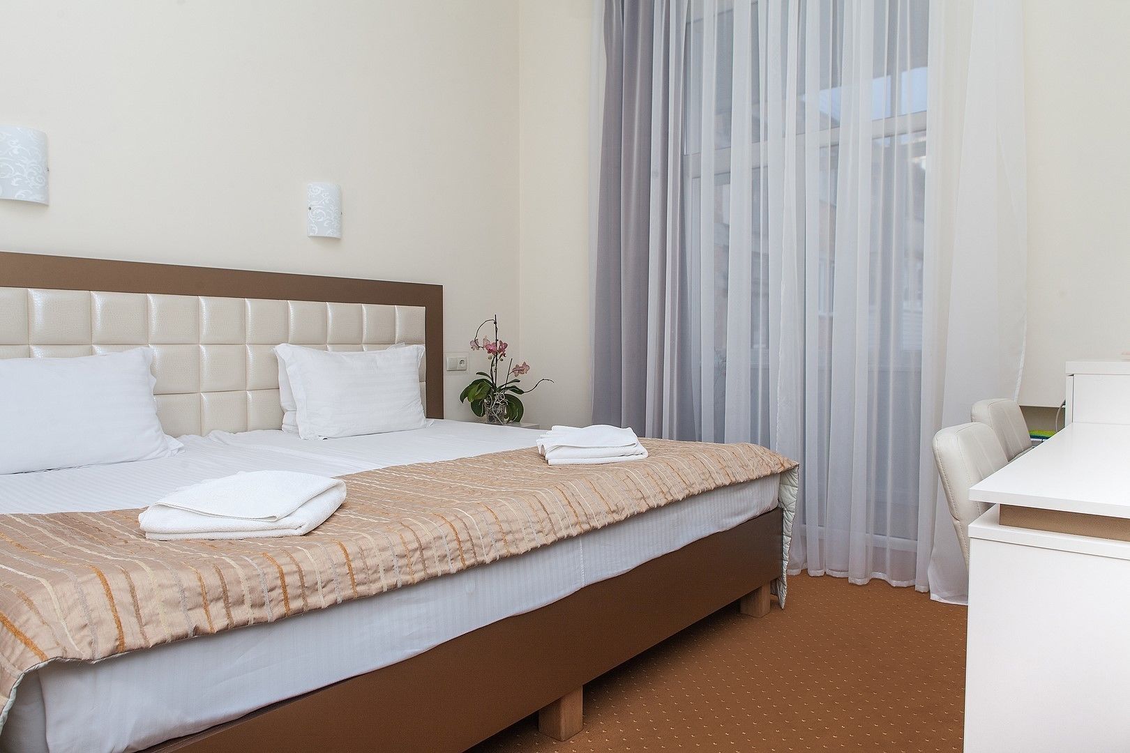 Ein Hotelzimmer mit einem Bett, einem Schreibtisch und einem Sessel.