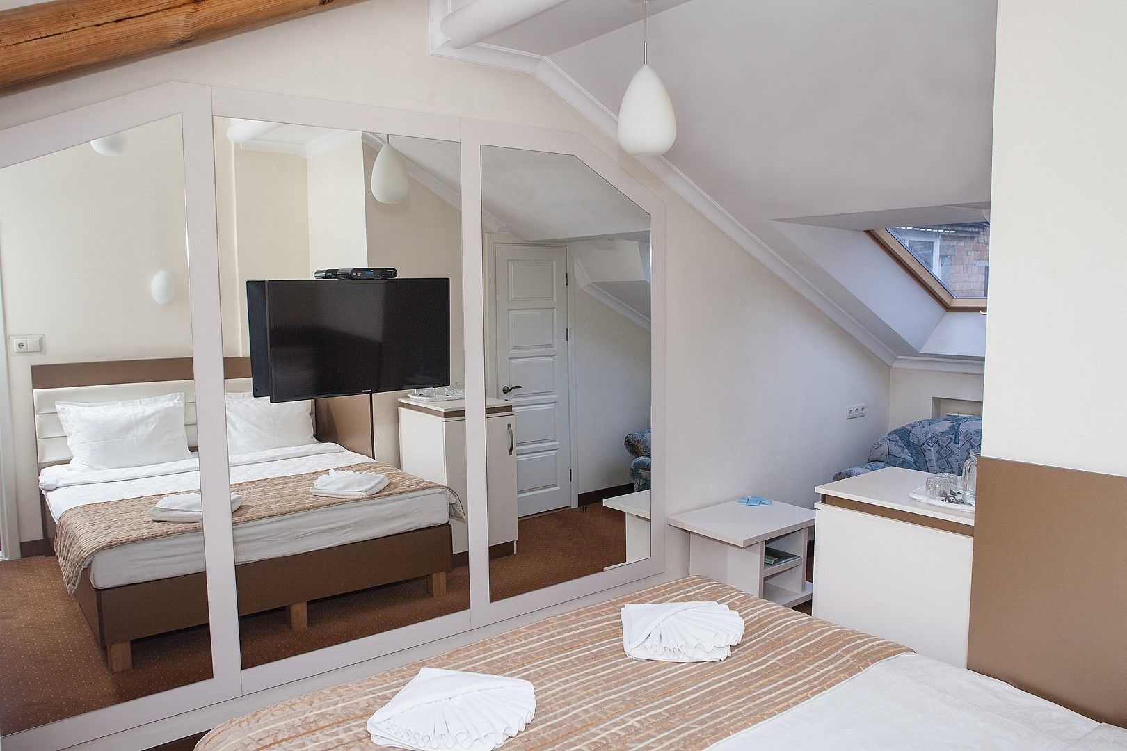 Una habitación de hotel con cama, televisión, escritorio y baño.