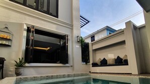Una casa moderna con piscina, garaje y un jardín bien cuidado.