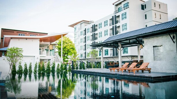 Un hôtel moderne doté d’une piscine, d’un espace extérieur aménagé et d’une zone couverte.
