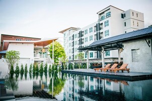 Una piscina al aire libre, camas de piscina gratis, sombrillas