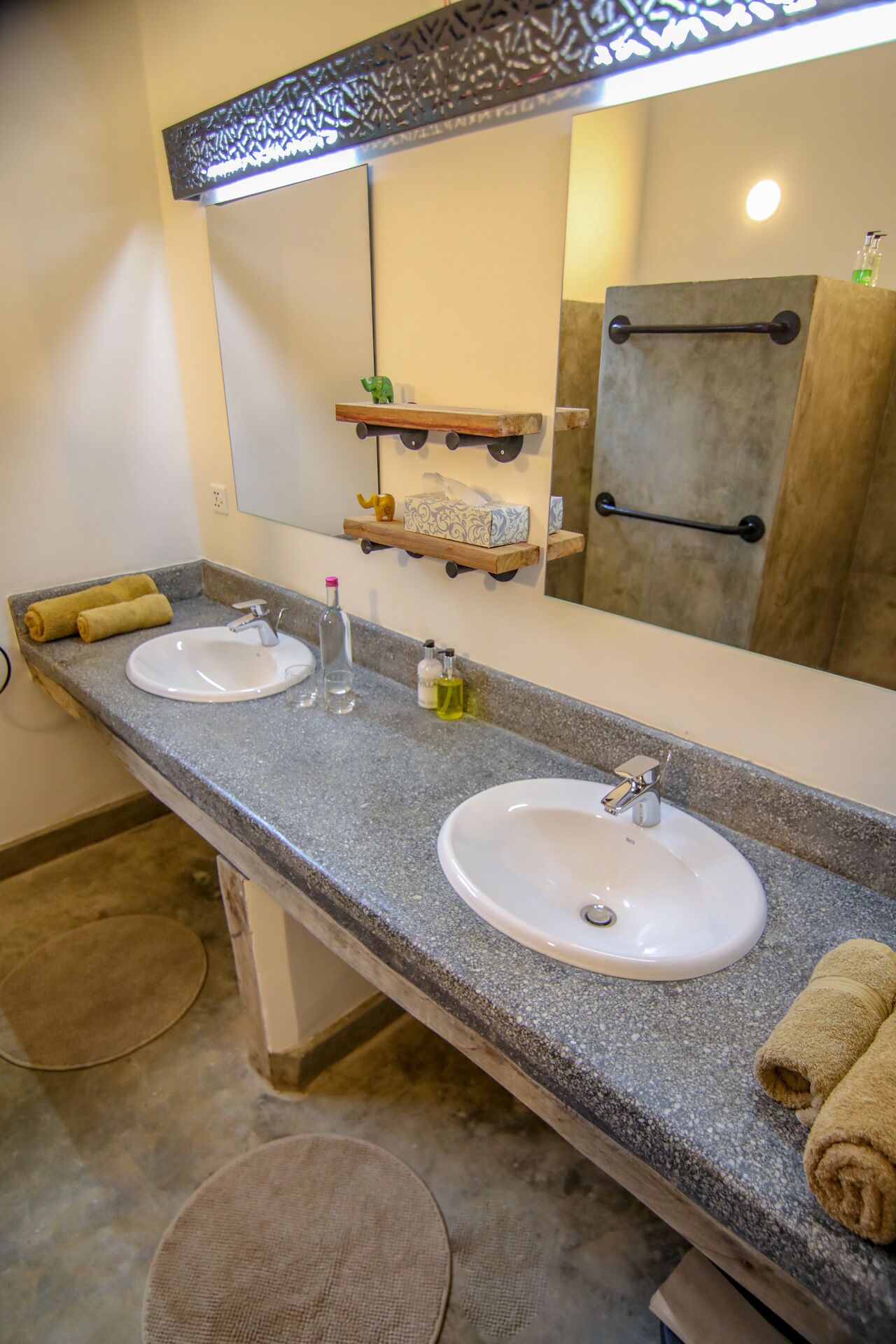 A bathroom with two sinks, a mirror, and a towel rack.