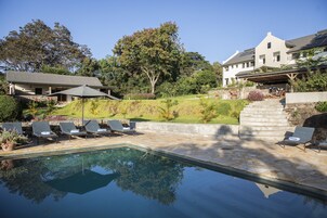 Una piscina al aire libre, tumbonas