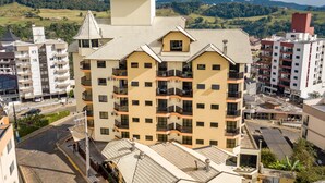 Een meerlaags hotel met een opvallend architectuurontwerp, voorzien van balkons en een centrale binnenplaats.