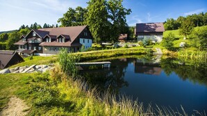 A lakeside property with multiple buildings, a dock, and a pond. - Chata Pod Lipami (Rokytnice nad Jizerou)