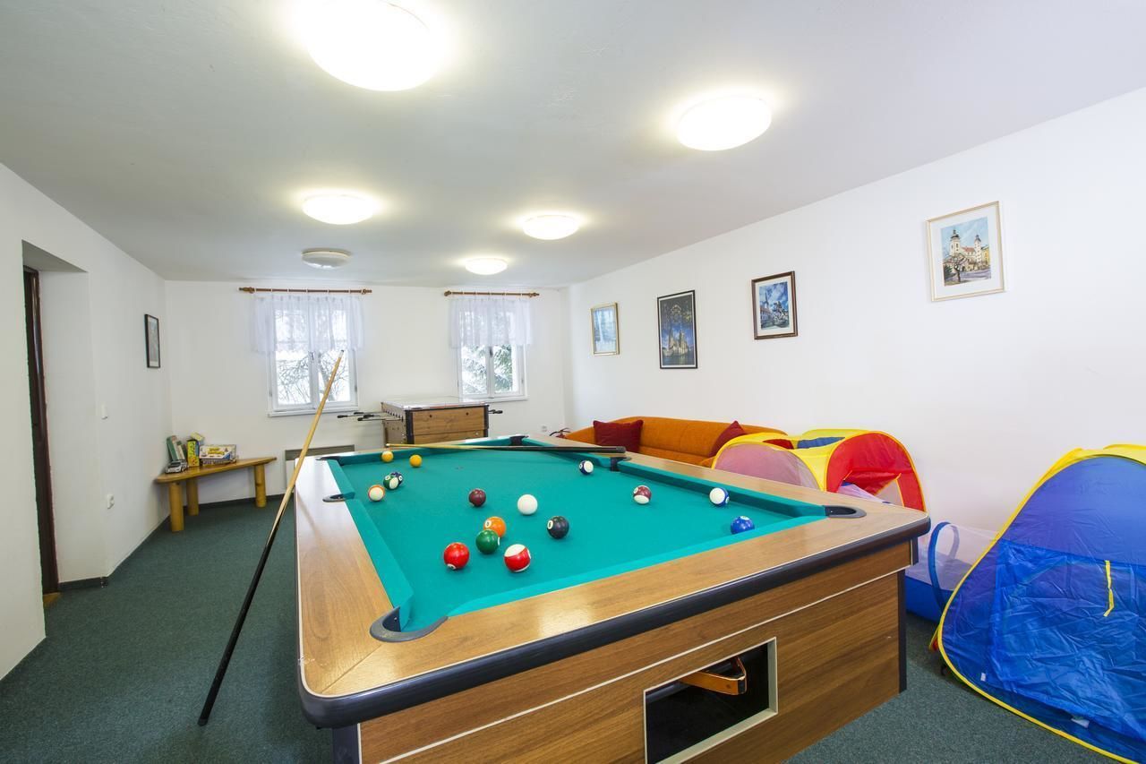 Ein Billardtisch mit Kugeln, eine Couch, ein Zelt und gerahmte Bilder an der Wand.
