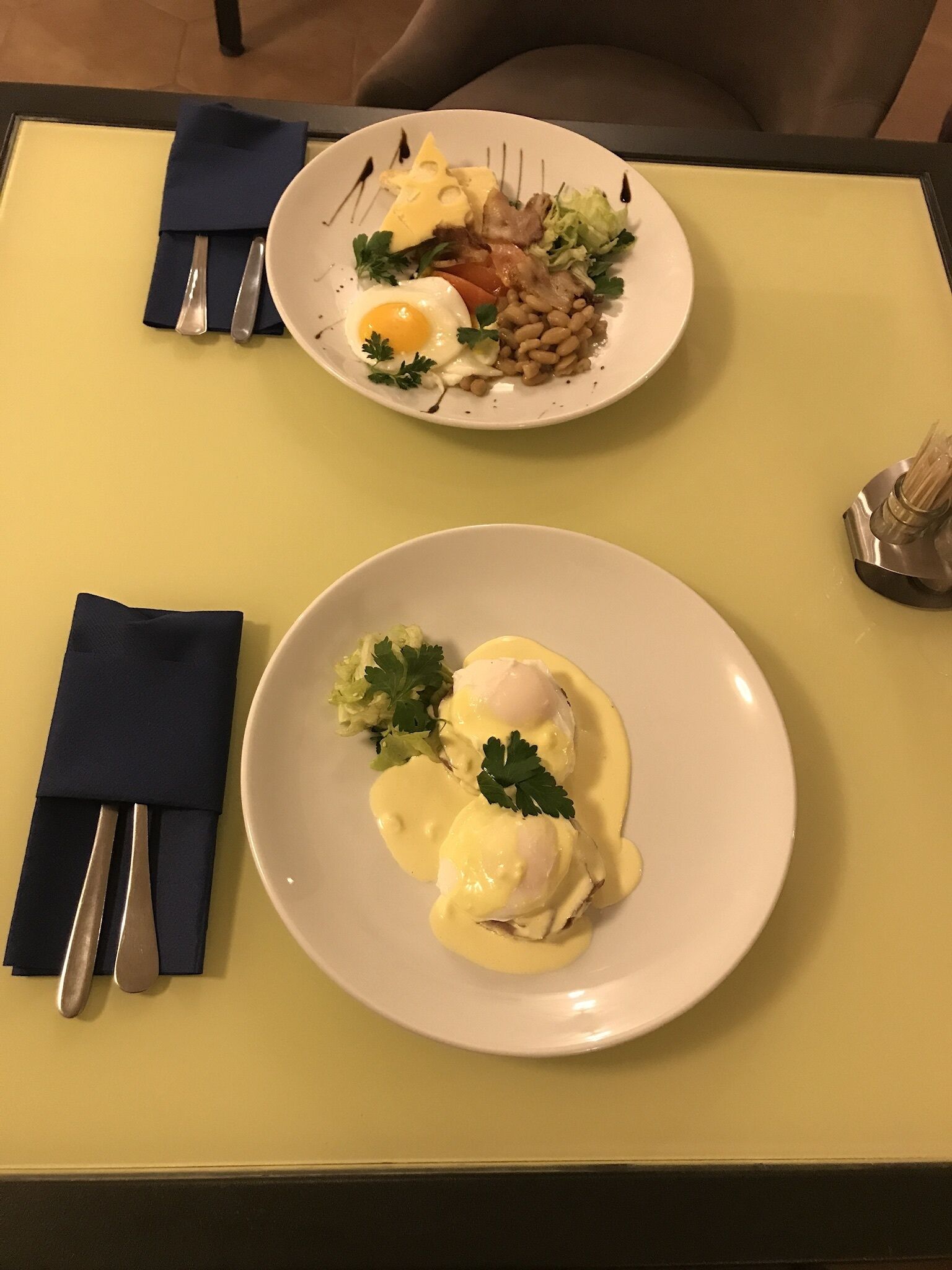 Dos platos de comida sobre una mesa con mantel amarillo.