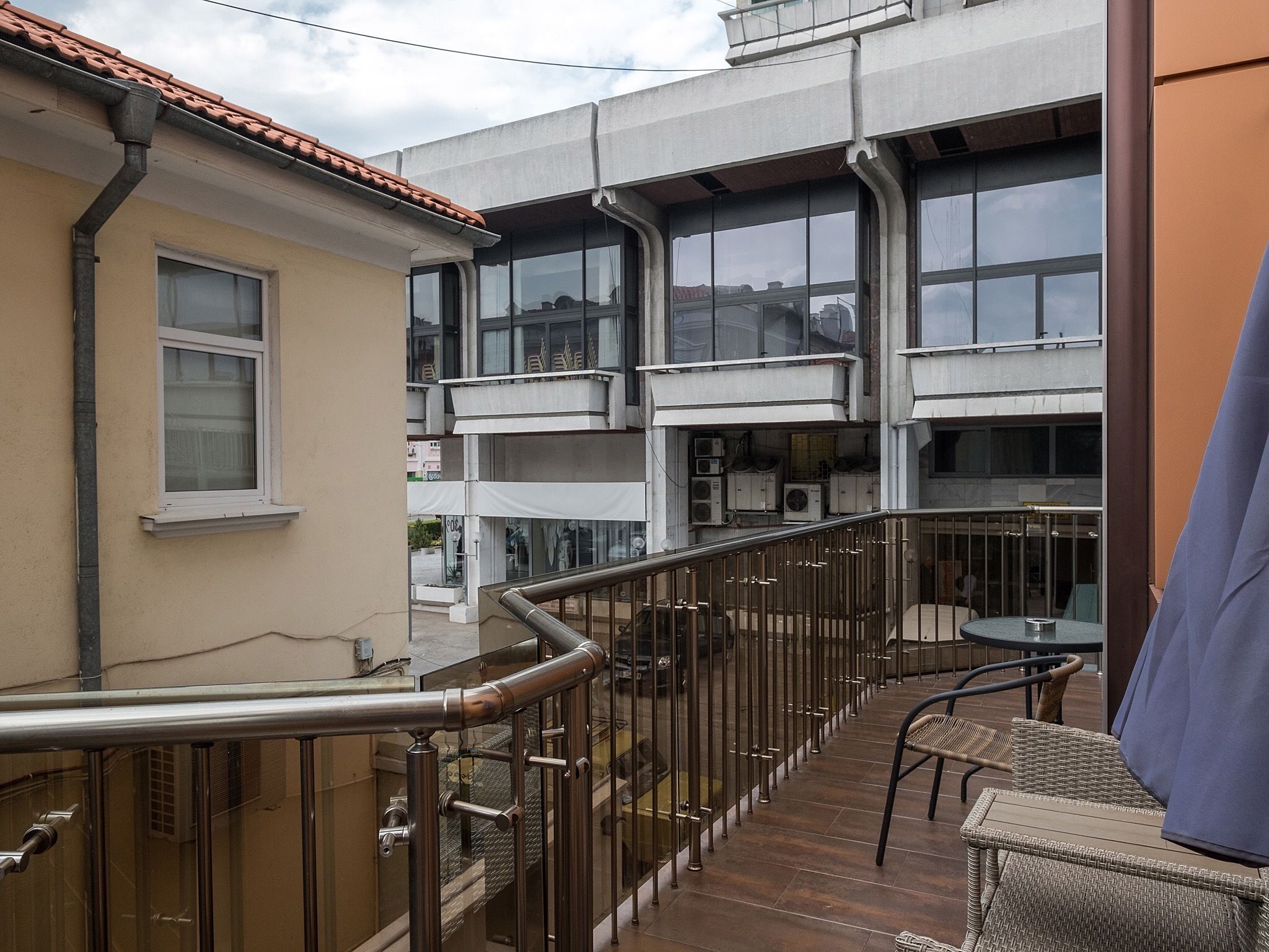 A balcony with a metal railing, a table, and chairs.