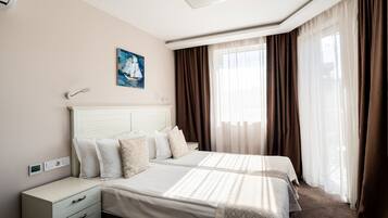 Una habitación de hotel con una cama grande, una mesita de noche y un cuadro en la pared.