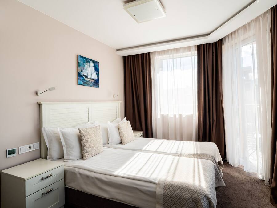 Una habitación de hotel con una cama grande, una mesita de noche y un cuadro en la pared.