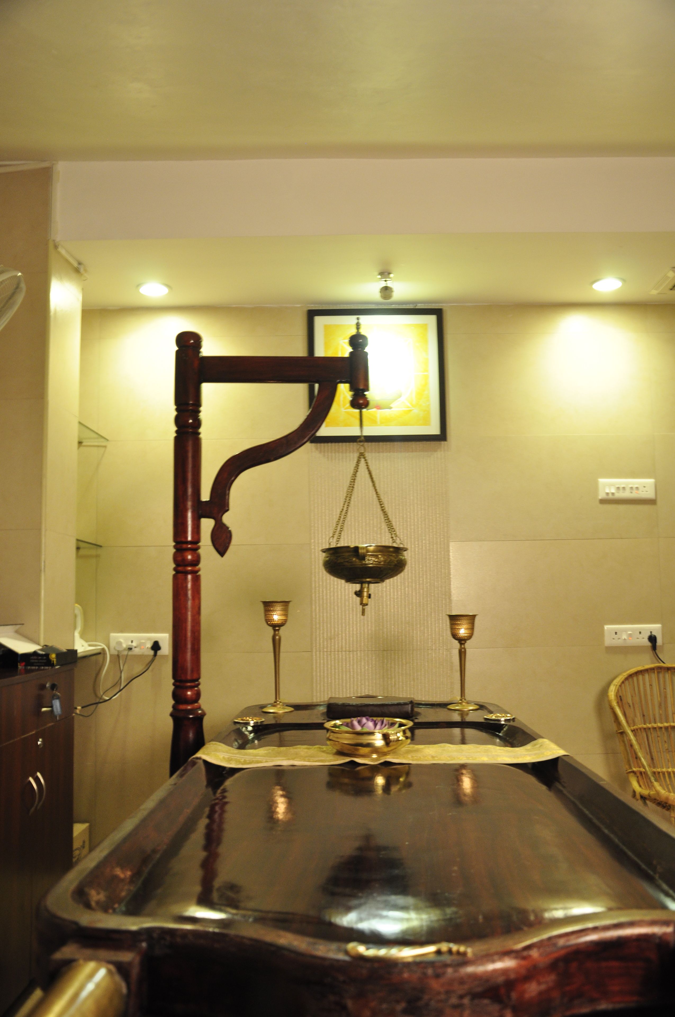 A room with a wooden table, a hanging scale, and a framed picture on the wall.