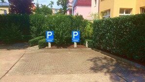 Ein Parkplatz mit zwei blauen Hinweisschildern, auf denen 'P Gaste' steht.