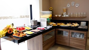 A breakfast buffet with various fruits, pastries, and beverages. - Hotel King (São José do Rio Preto)