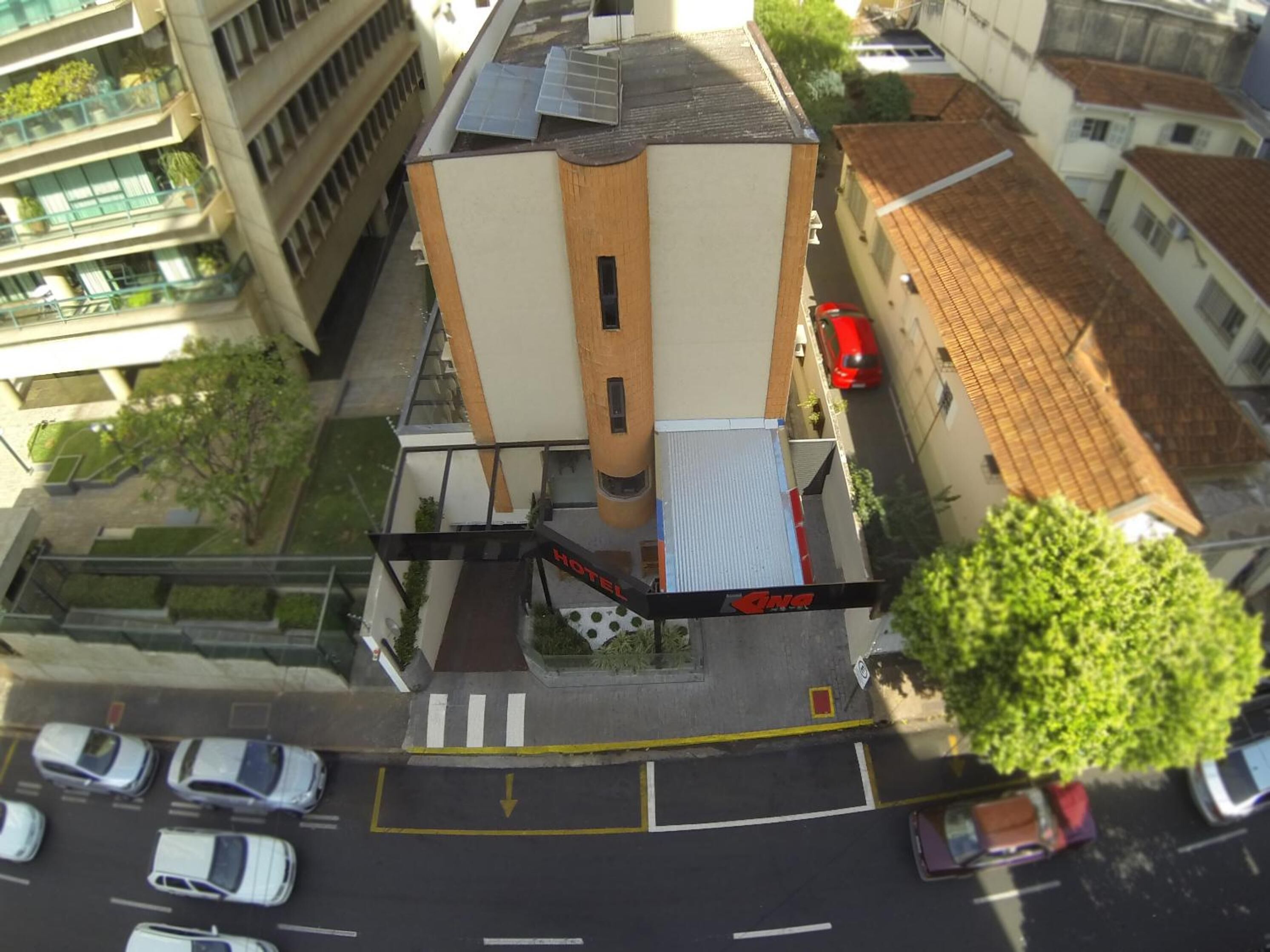 A hotel with a modern design, featuring a central tower and a flat-roofed structure.