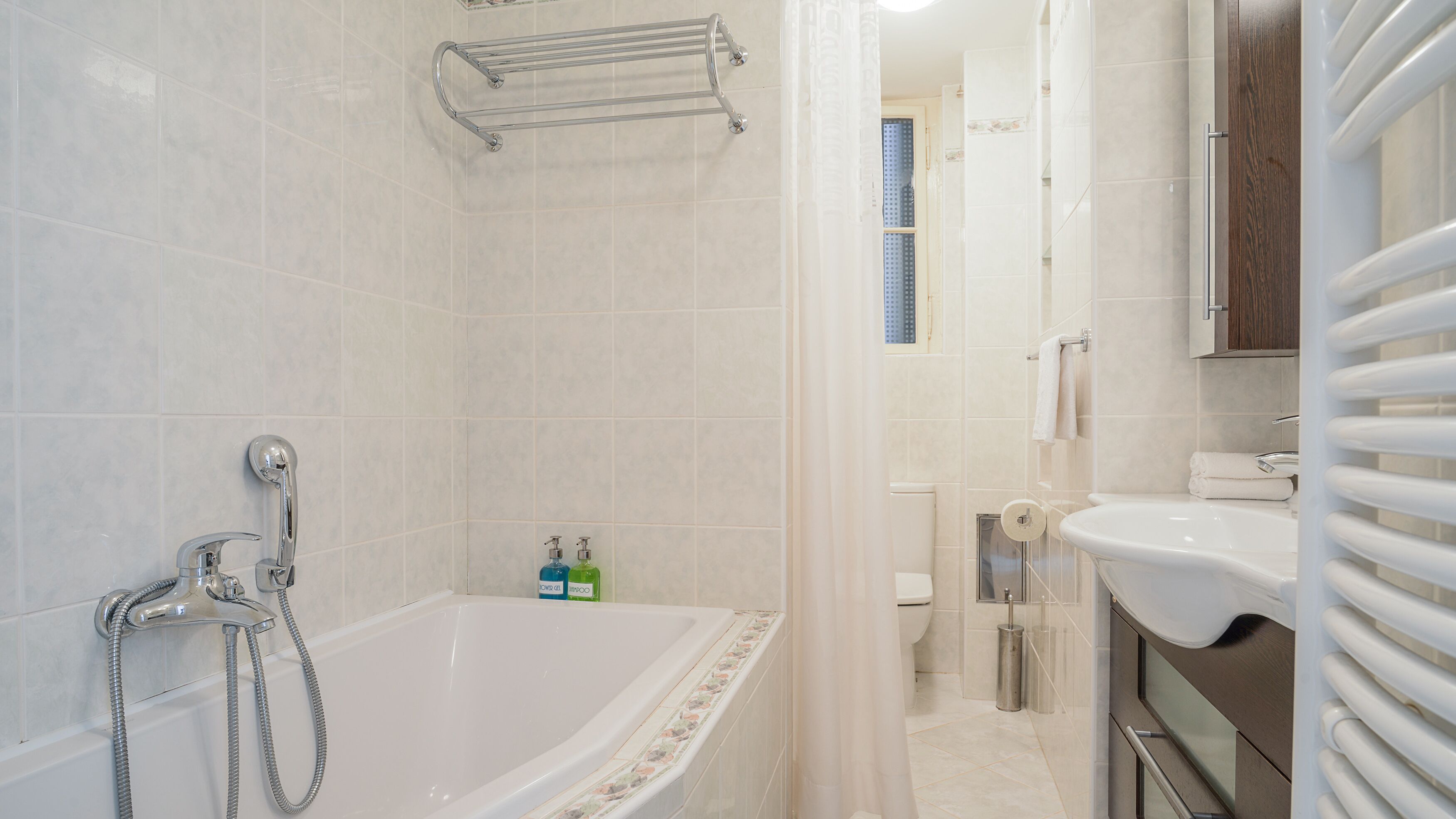 Un bagno moderno con vasca, doccia, toilette e lavandino.