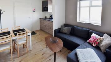 Una sala de estar moderna con un sofá, una mesa de centro y un comedor con sillas y una mesa.
