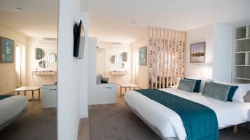 Et moderne hotelværelse med en stor seng, et skrivebord og en stol. Der er flere spejle på væggene og en dekorativ rumdeler.