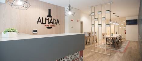 Un espace d’accueil avec un mur en bois, un comptoir et un coin repas comprenant une table et des chaises.
