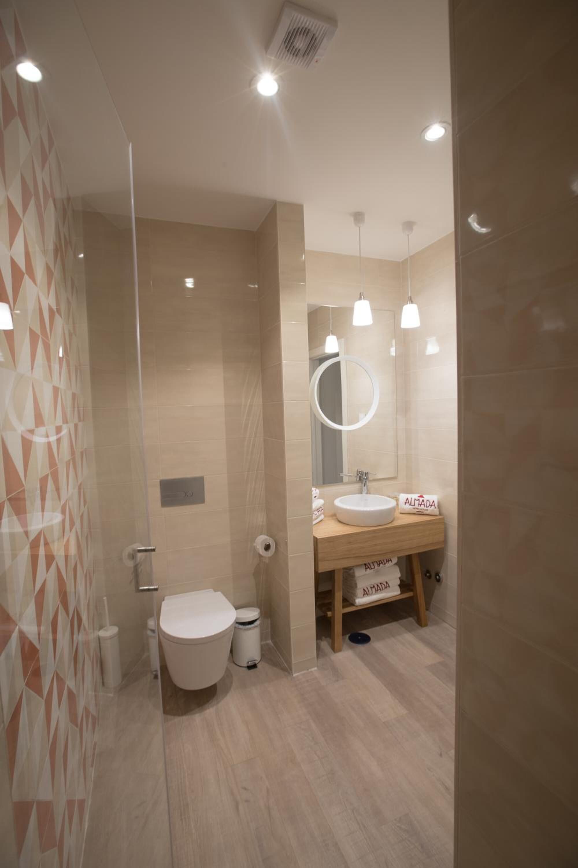 Une salle de bain moderne avec des toilettes, un lavabo et un miroir.