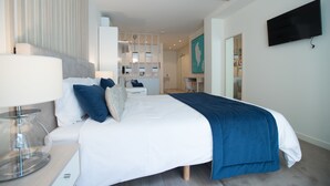 A modern bedroom with a bed, bedside table, lamp, and a flat-screen TV mounted on the wall. - Almada Wine House (Porto)