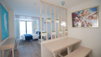 Une chambre d’hôtel moderne dotée d’un grand lit, d’un bureau, d’une banquette, d’un paravent décoratif et d’une grande fenêtre.