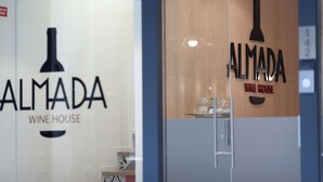 A wine house with a logo and name displayed on the glass door. - Almada Wine House (Porto)