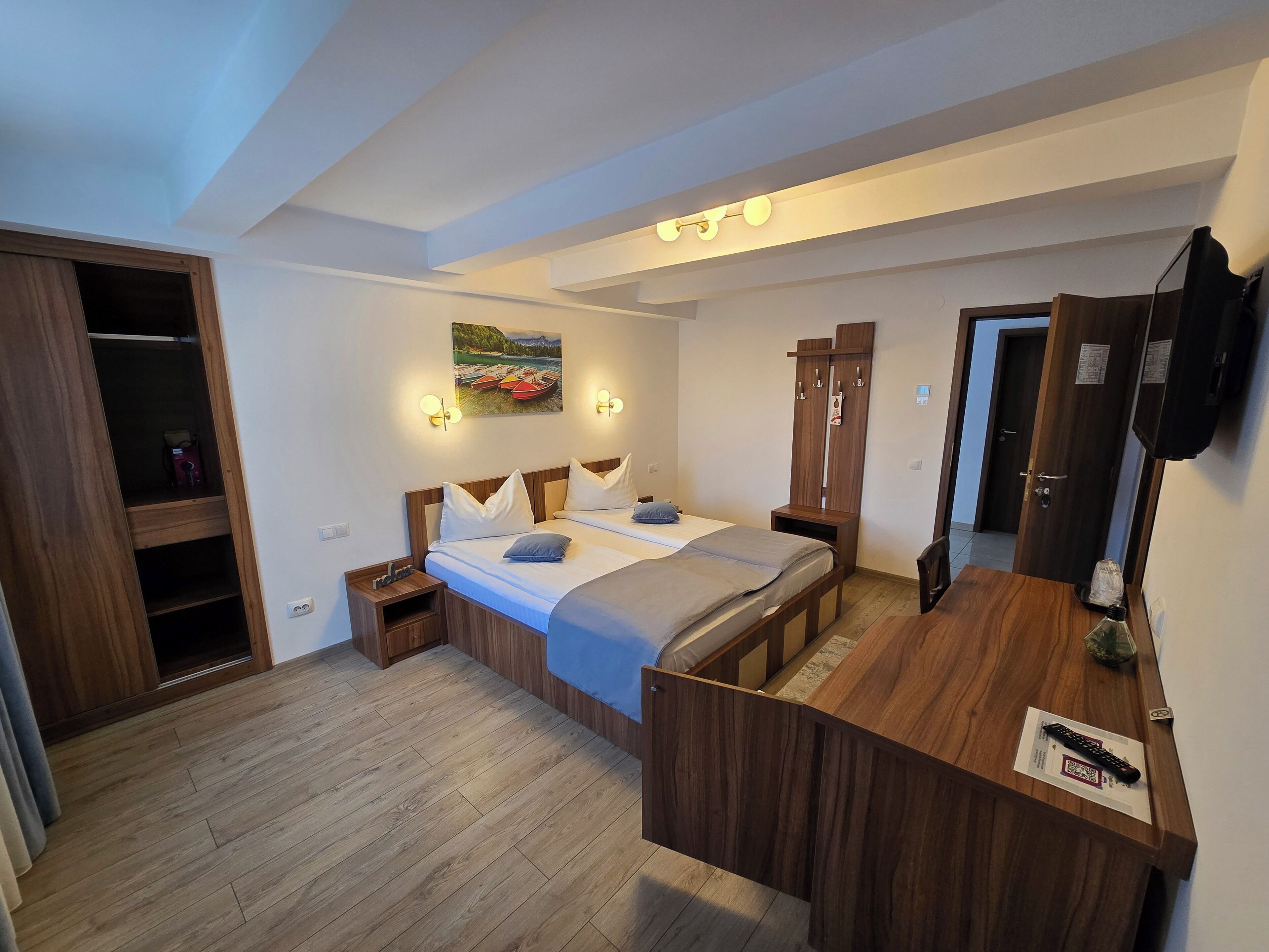 A bedroom with a bed, bedside tables, a wardrobe, and a desk with a chair.