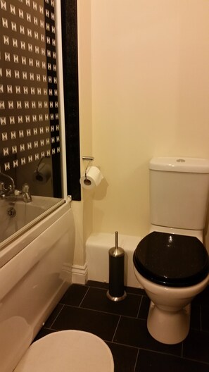 A bathroom with a bathtub, toilet, and sink. - Livingston Ideal Commuter Townhouse (Livingston)