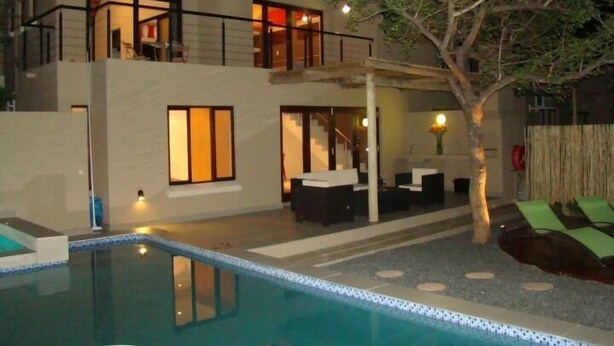 A two-story house with a swimming pool, outdoor seating, and a tree. - BushGlam Luxury Holiday Home (Hoedspruit)