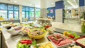 Un buffet proposant une variété de plats, notamment des salades, de la viande et du riz.