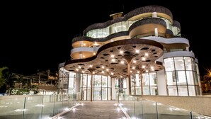 A modern hotel with a unique architectural design featuring curved balconies and a glass facade. - GF Victoria (Adeje)