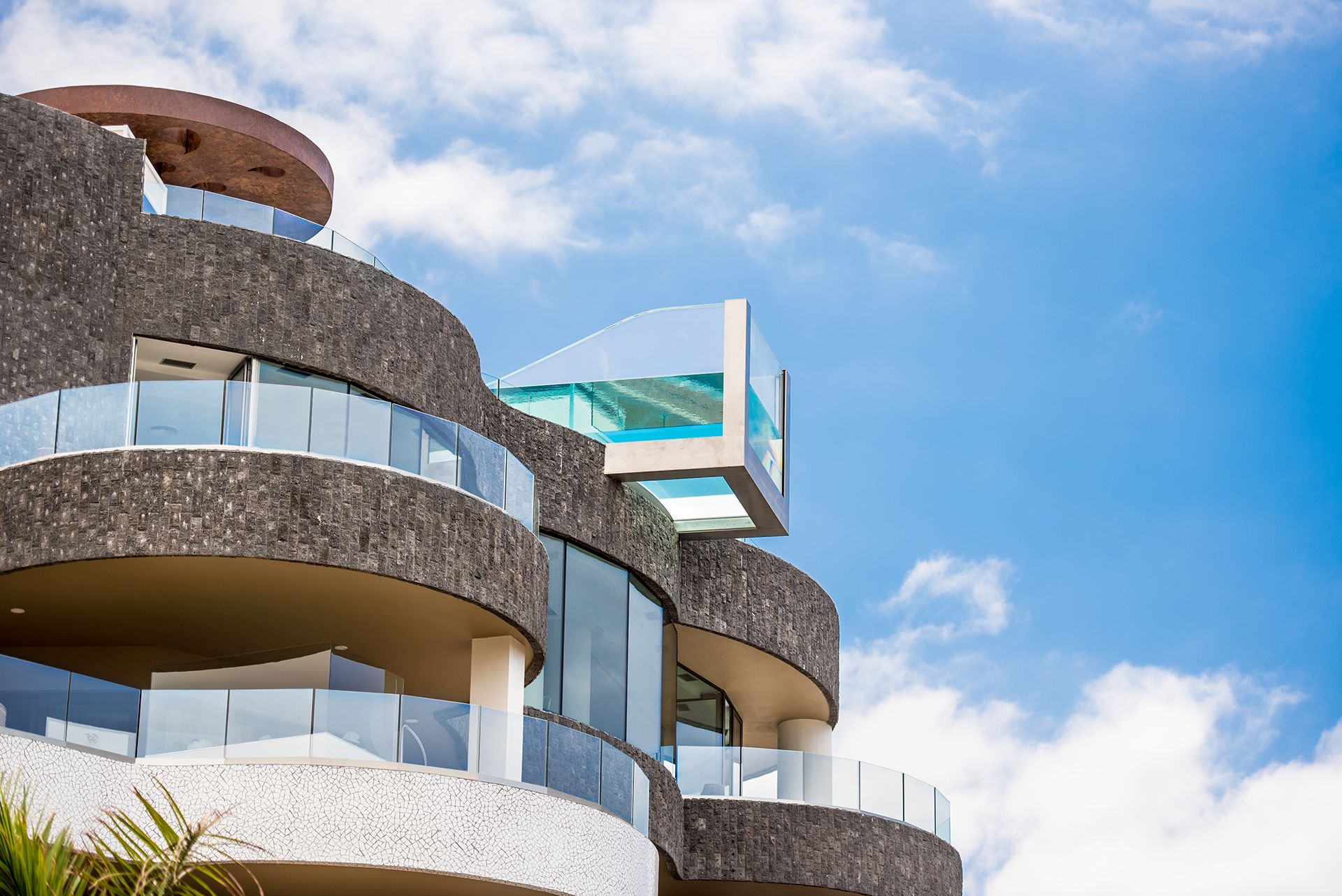 Een modern gebouw met meerdere balkons en een glazen gevel.