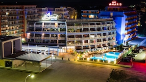 A multi-story hotel with balconies, a swimming pool, and a covered outdoor area. - Hotel Bohemi (Sunny Beach)