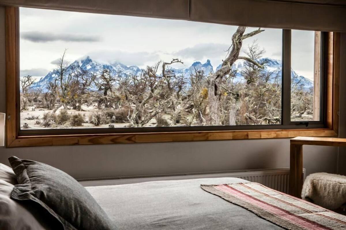 Une chambre avec une grande fenêtre donnant sur un paysage montagneux.