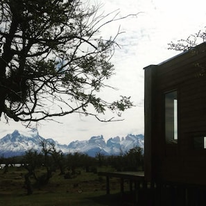 A cabin with a view of snow-capped mountains.