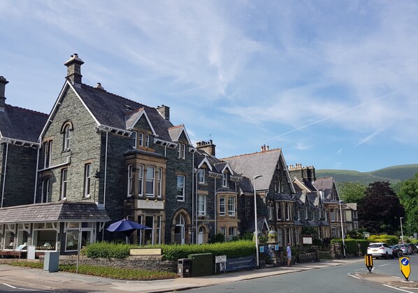 A row of traditional stone buildings with arched windows and a sign for 'Restwick Park Restaurant'. - Keswick Park Hotel (Keswick)