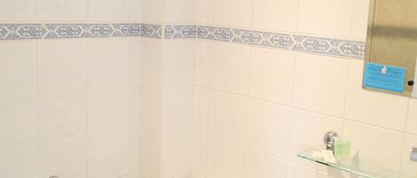 Un baño con inodoro, lavamanos y un borde decorativo de azulejos azules.