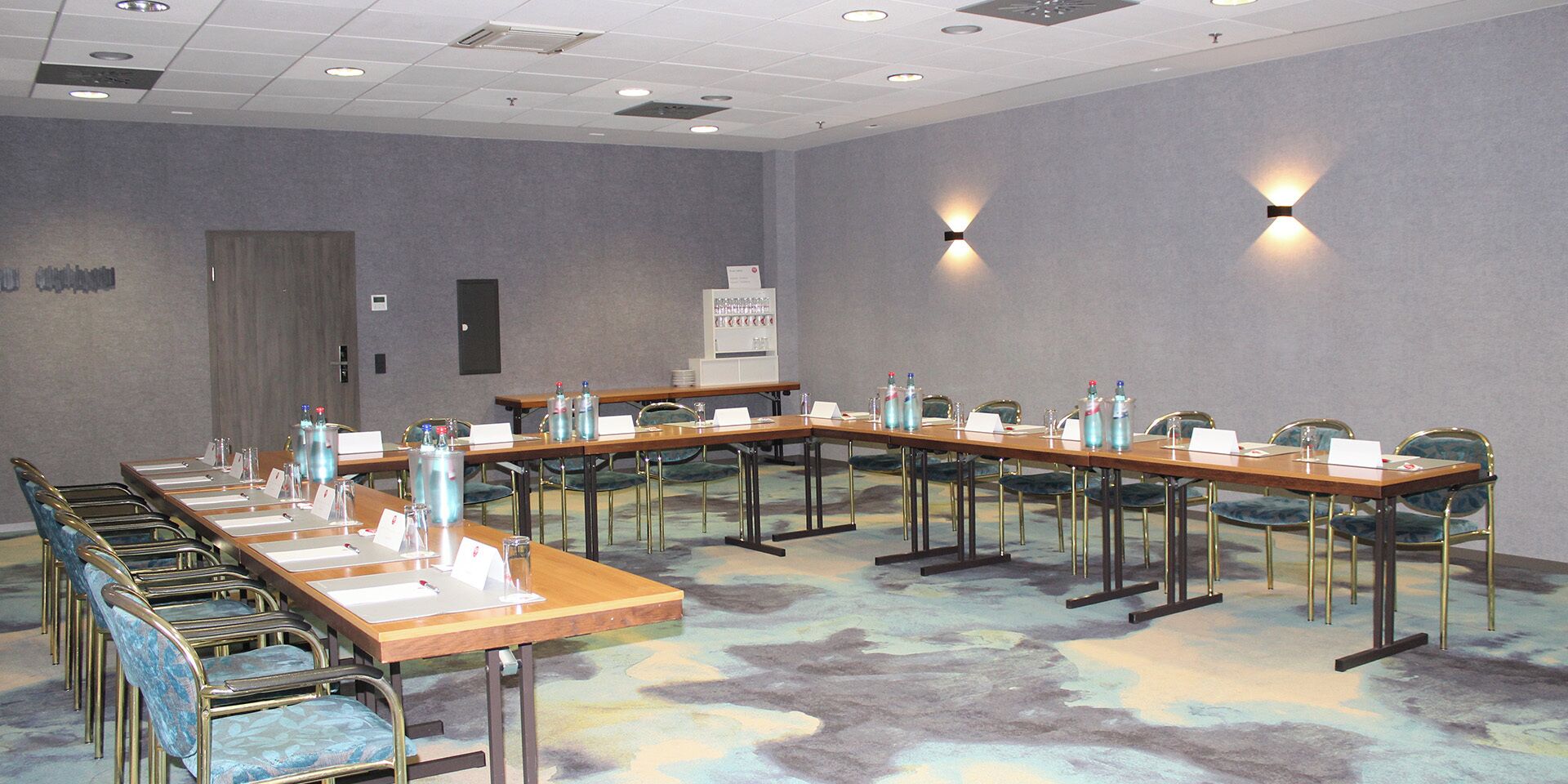 A conference room with long tables, chairs, and name cards.