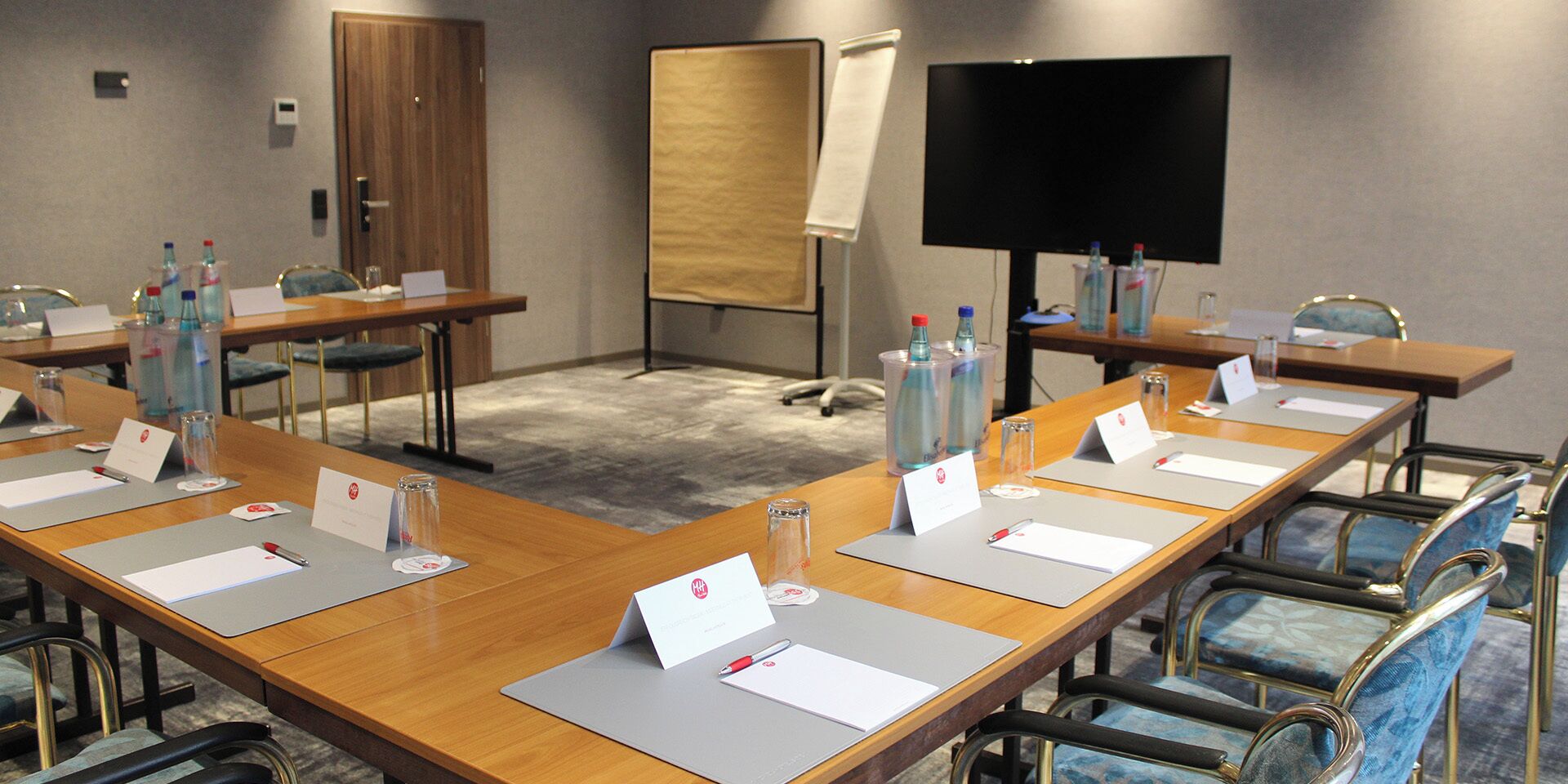 A conference room with long tables, nameplates, and water bottles.