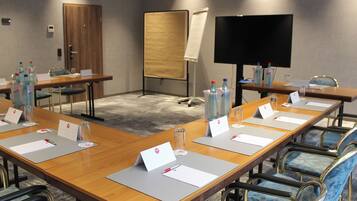 A conference room with long tables, nameplates, and water bottles.