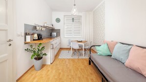 A compact living space with a kitchenette, dining area, and a sofa. - Pension Skylark (Pardubice)