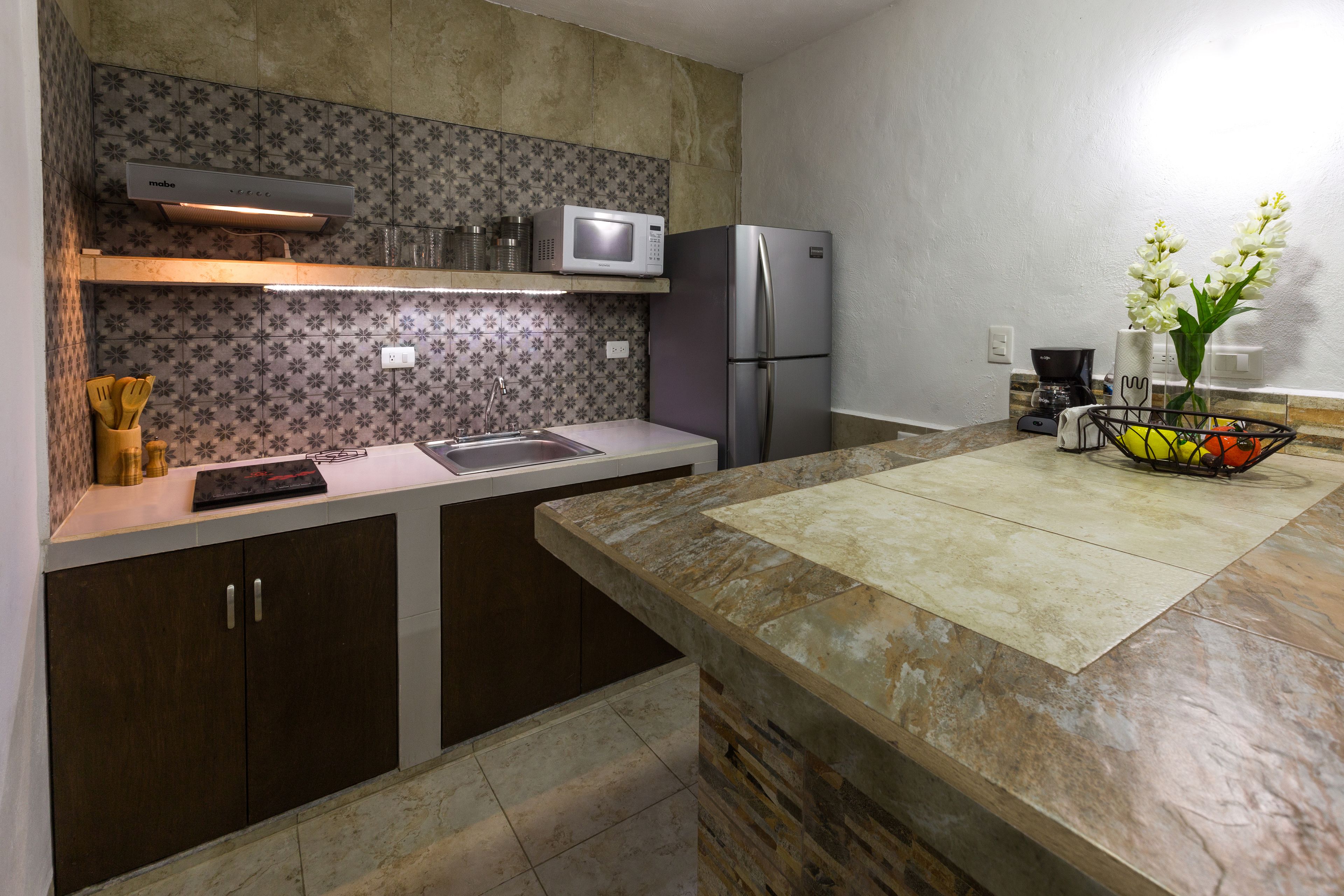 Una cucina moderna con forno a microonde, frigorifero e lavello.