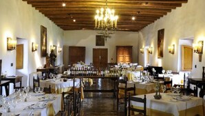 A restaurant with wooden beams, chandeliers, and tables set for dining. - Hotel Casa Real Viña Santa Rita (Buin)