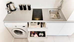 Una cocina compacta equipada con lavadora, estufa y lavaplatos.