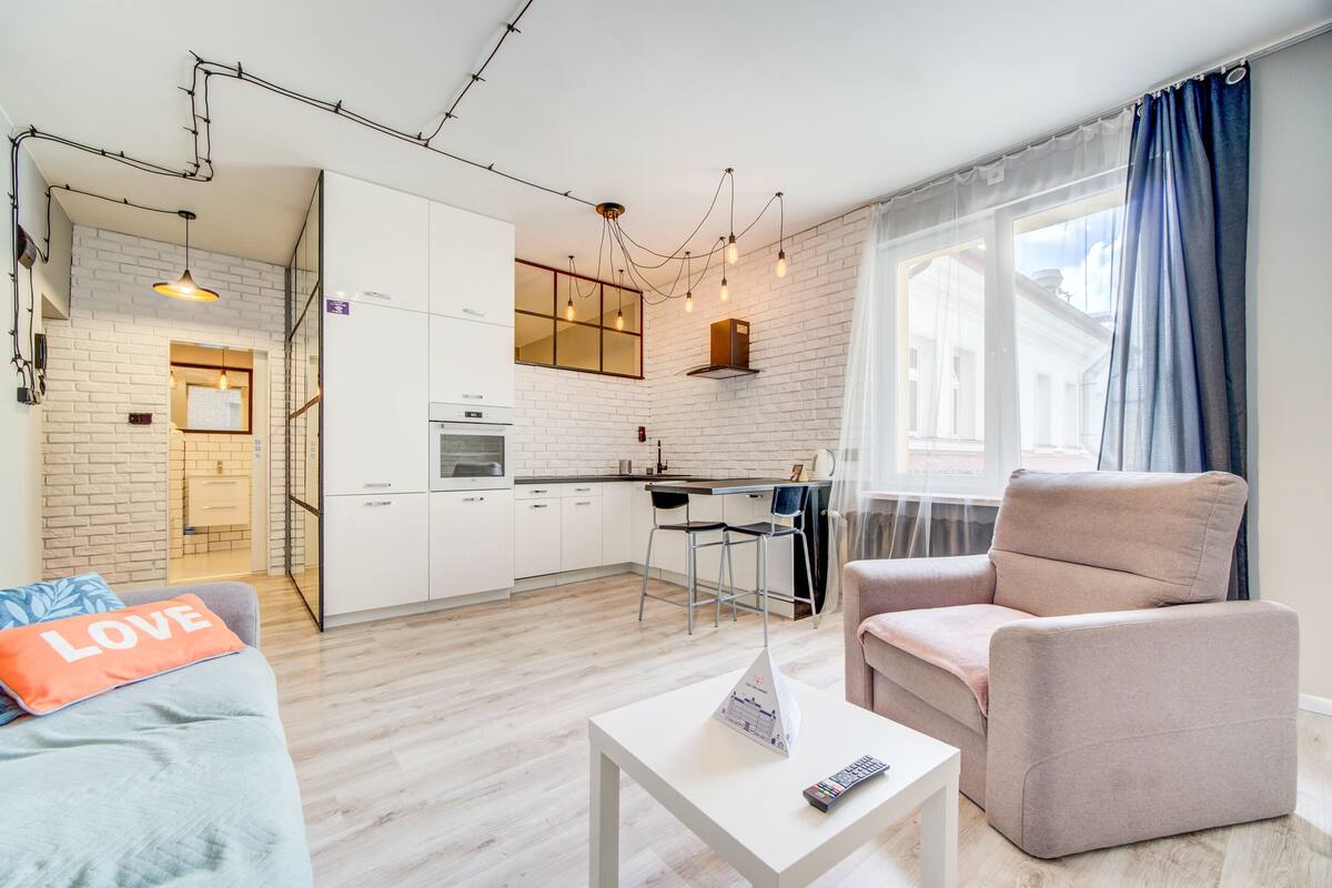 A modern apartment with a kitchen, dining area, and living room.