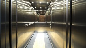 A modern elevator interior with metallic walls and a reflective floor. - Rint - Centrum Nowy Świat (Bialystok)