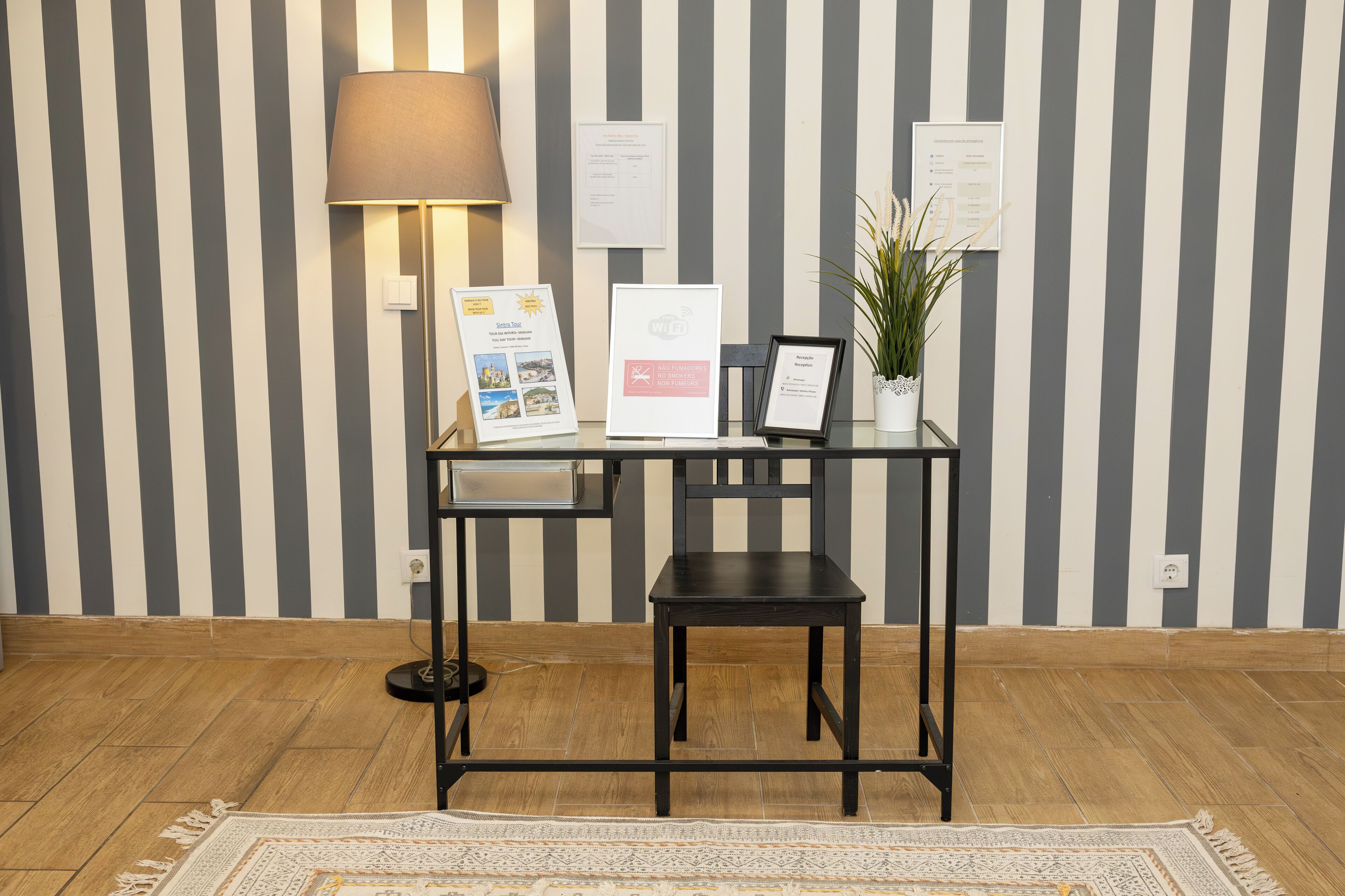 A reception desk with a lamp, framed certificates, and a potted plant.