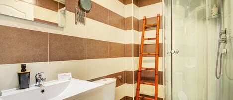 A bathroom with a bathtub, toilet, and a shower area.