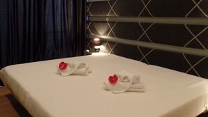 A hotel room with a large bed, a headboard with a geometric pattern, an air conditioning unit on the wall, and a bedside lamp. - Apartamentos Príncipe Apart-Center (Horta)