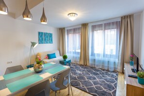 Apartamento superior, 1 habitación, en la zona del jardín (Blue) | Sala de estar | Televisión LED de 82 cm con canales por cable, una televisión